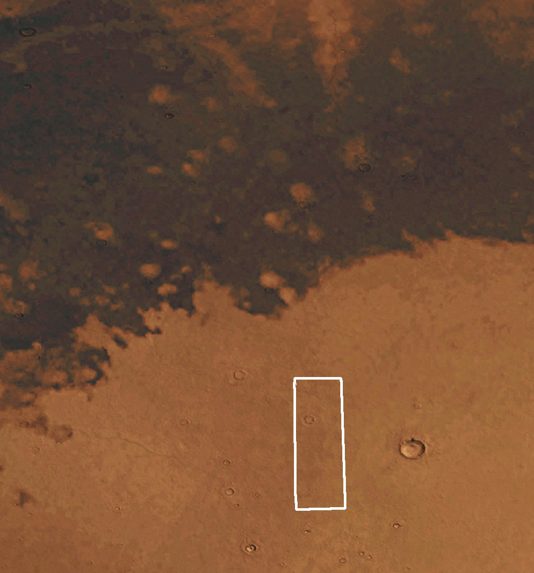 Mars yüzeyinin kahverengi ve turuncu tonlarda üstten harita görünümü. Üst kısım daha koyu ve benekli, alt kısım ise daha açık renkli ve pürüzsüzdür. İnce beyaz bir dikdörtgen, merkeze yakın dikey bir bölümü vurgular.